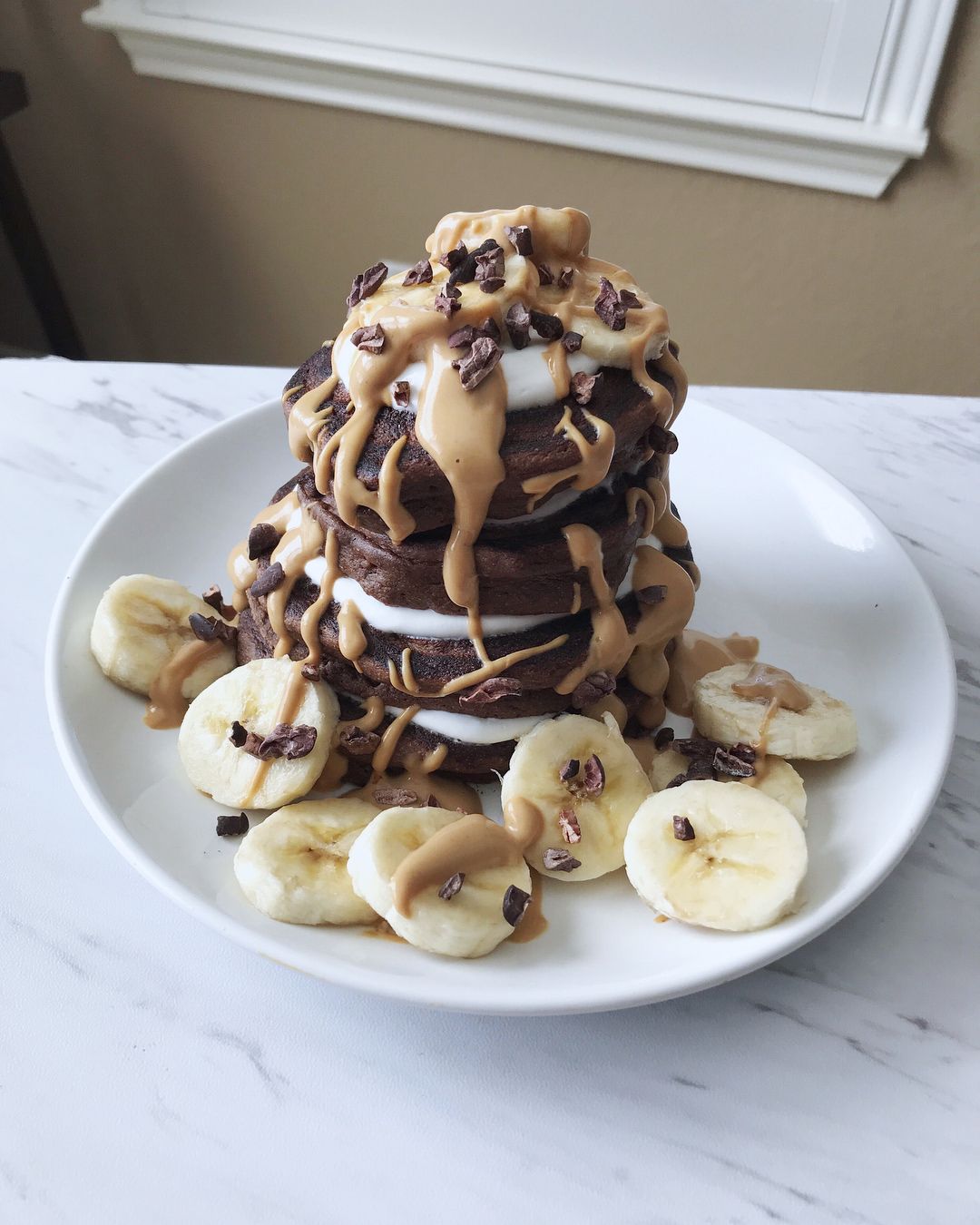 Delicious chocolate pancakes stacked high with peanut butter.