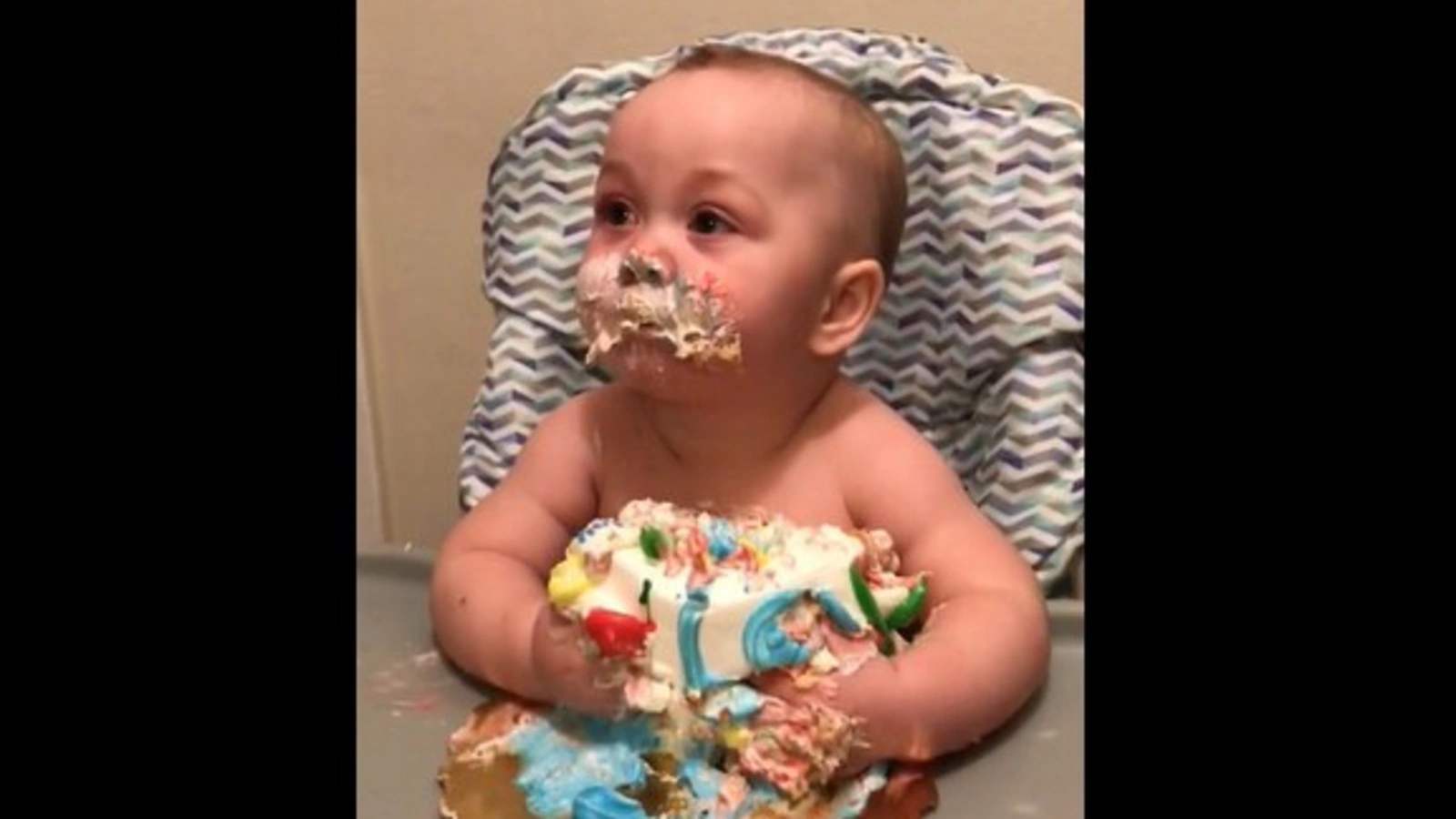 Baby eating birthday cake happily
