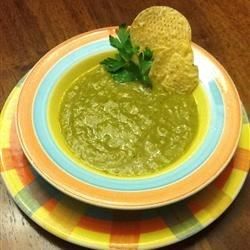 A bowl of green salsa with tortilla chips