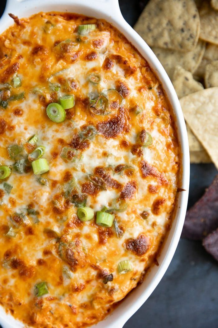 Up-close image of cheesy baked buffalo chicken dip in a white baking dish