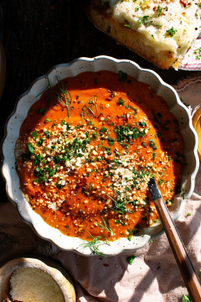 A bowl of Spicy Tomato Soup topped with fresh herbs
