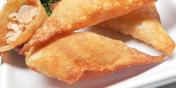 some fried food on a white plate with broccoli and other foods in it
