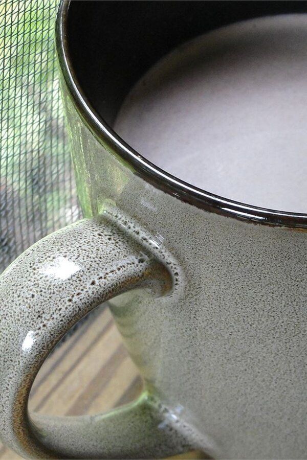 A delightful cup of hot chocolate topped with whipped cream and a sprinkle of cocoa.