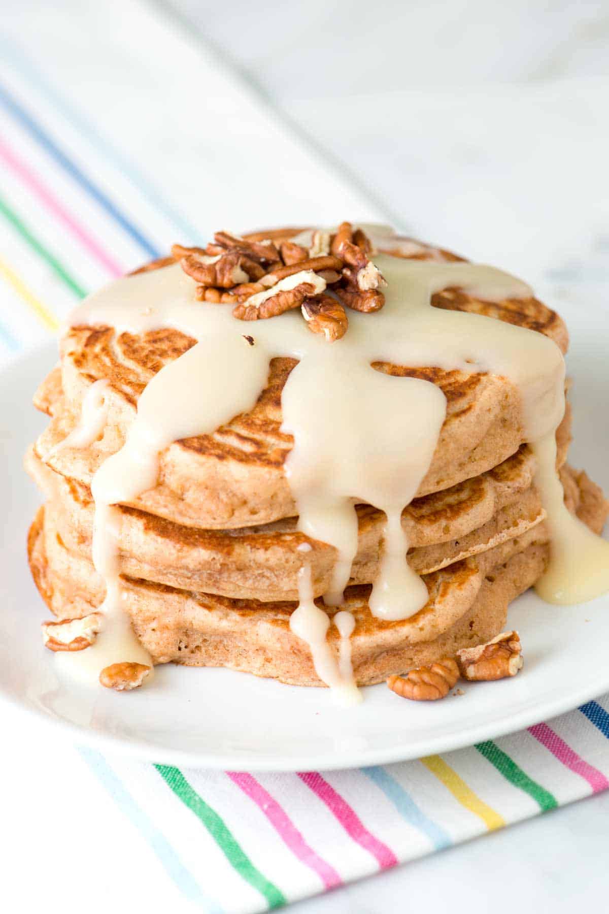 Delicious cinnamon pancakes stacked on a plate with syrup