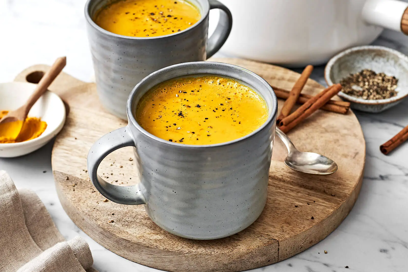 Golden Milk in a bowl with spices surrounding it.