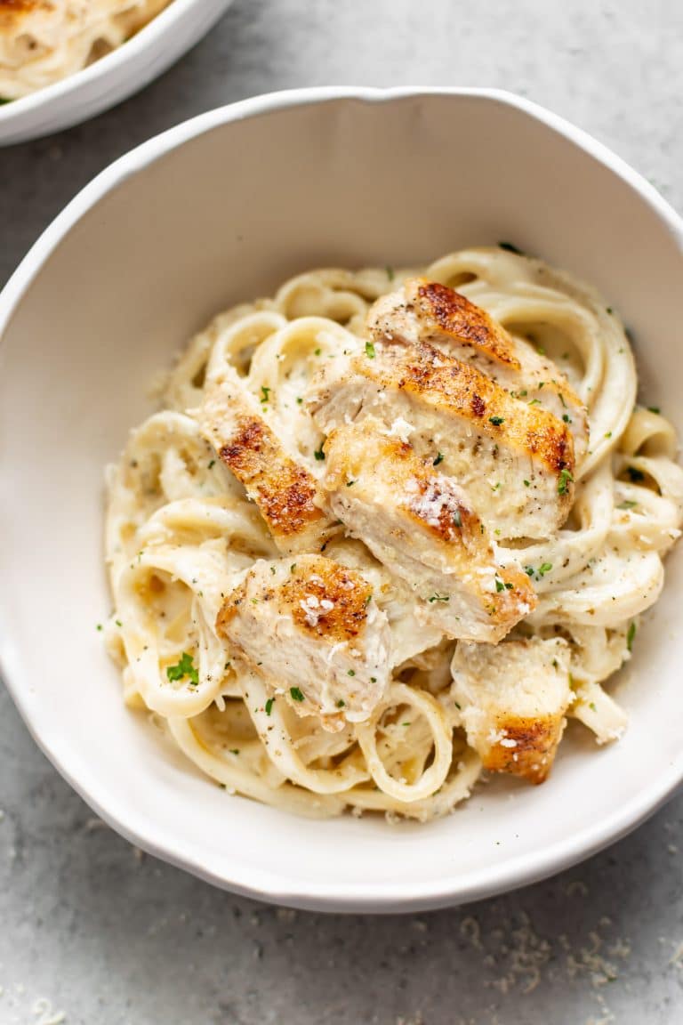 A delectable plate of Chicken Fettuccine Alfredo, showcasing its creamy sauce and garnished chicken.