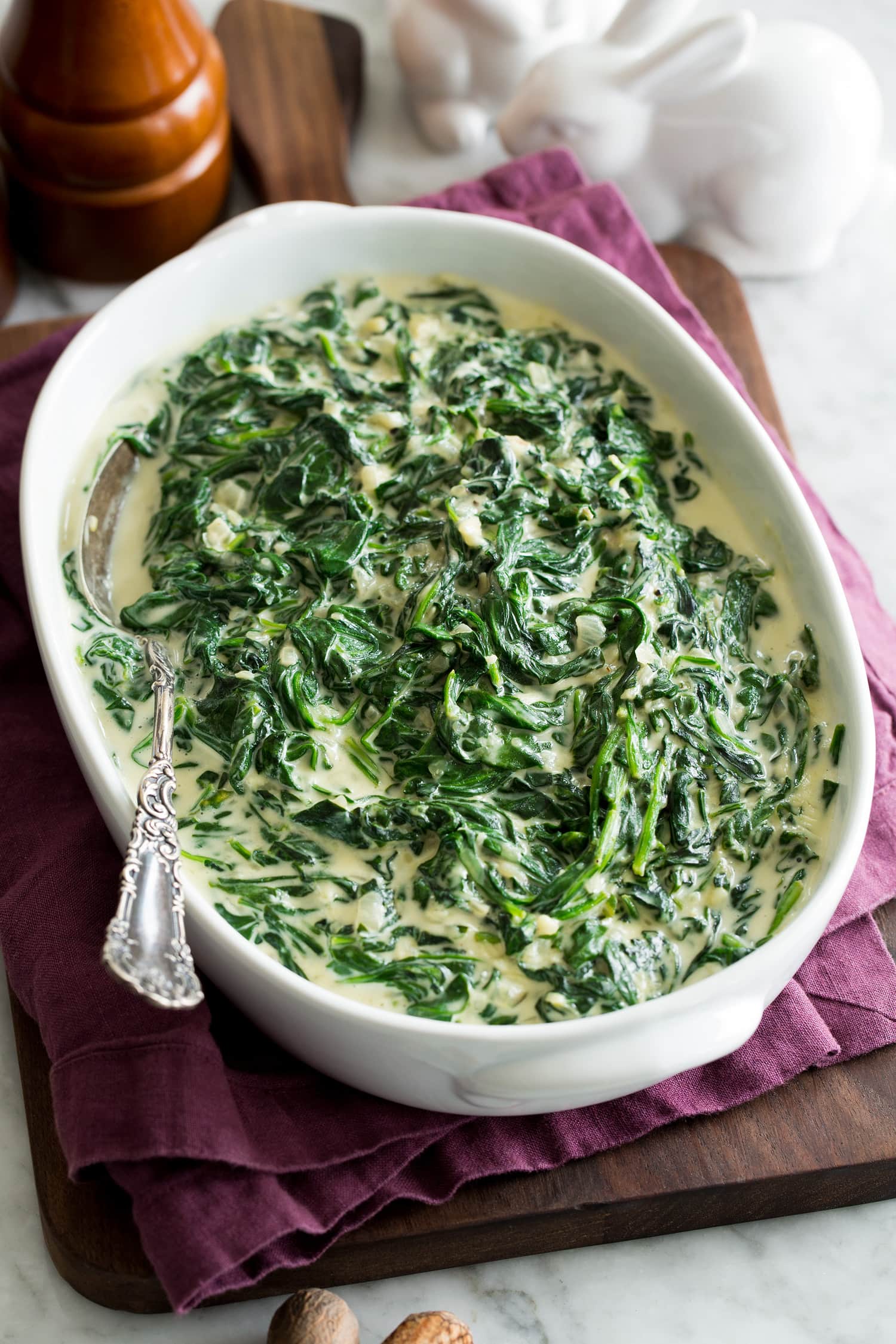 A bowl of creamy spinach garnished with a sprinkle of Parmesan cheese