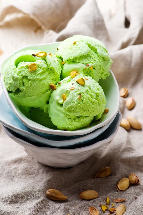Pistachio ice cream in a bowl with a sprinkle of pistachios on top